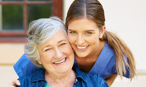 Senior woman with caregiver in a memory care community