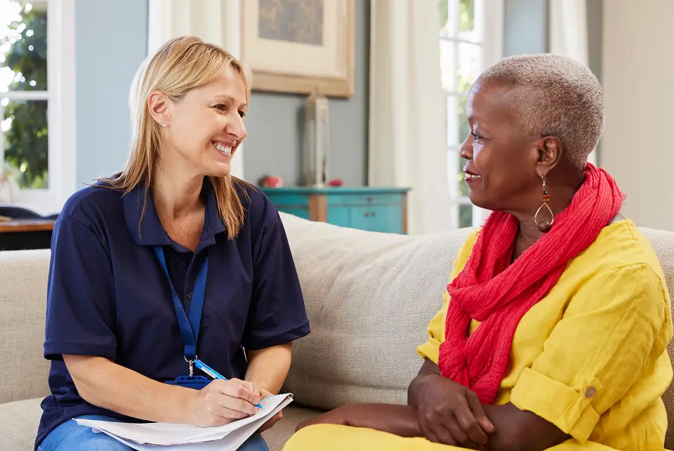Senior living caregiver talking with an older woman